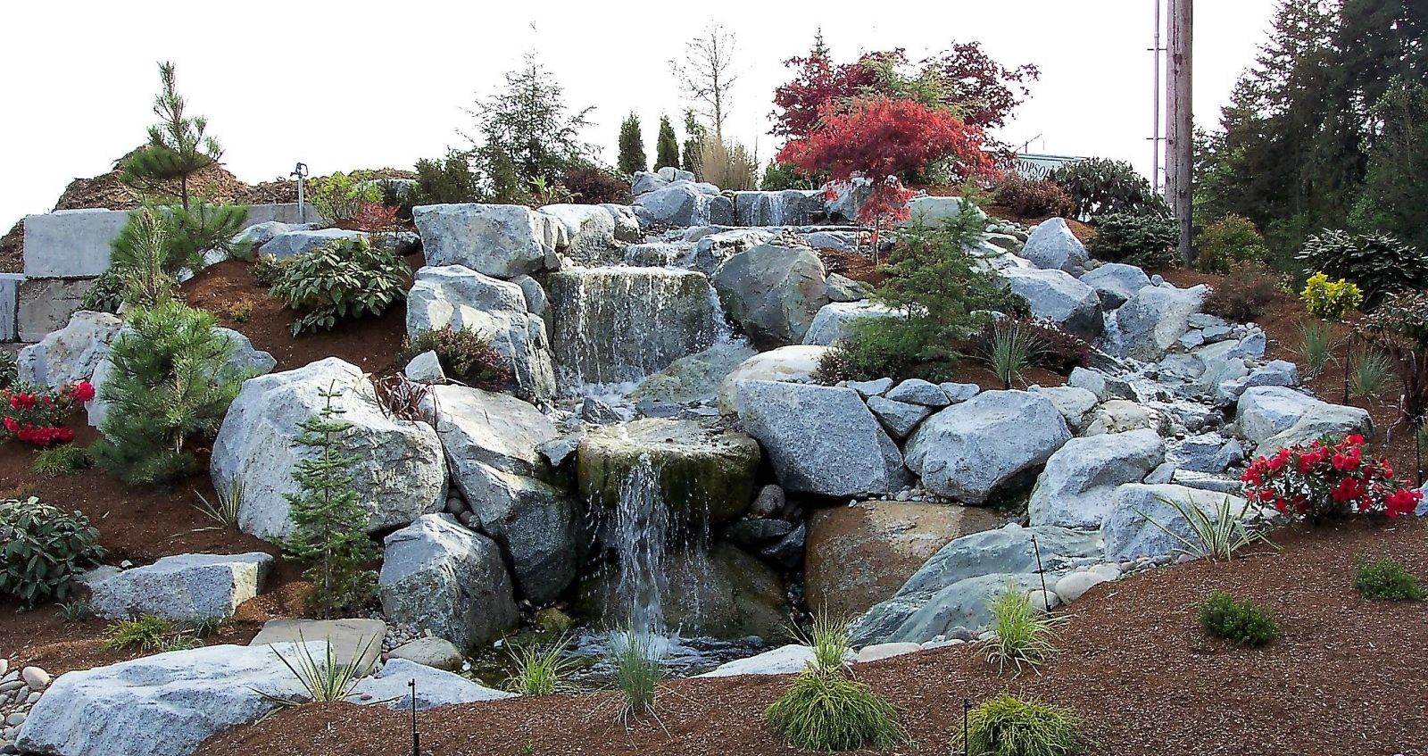 Boulder waterfall water feature built by Sage Landscape & Design